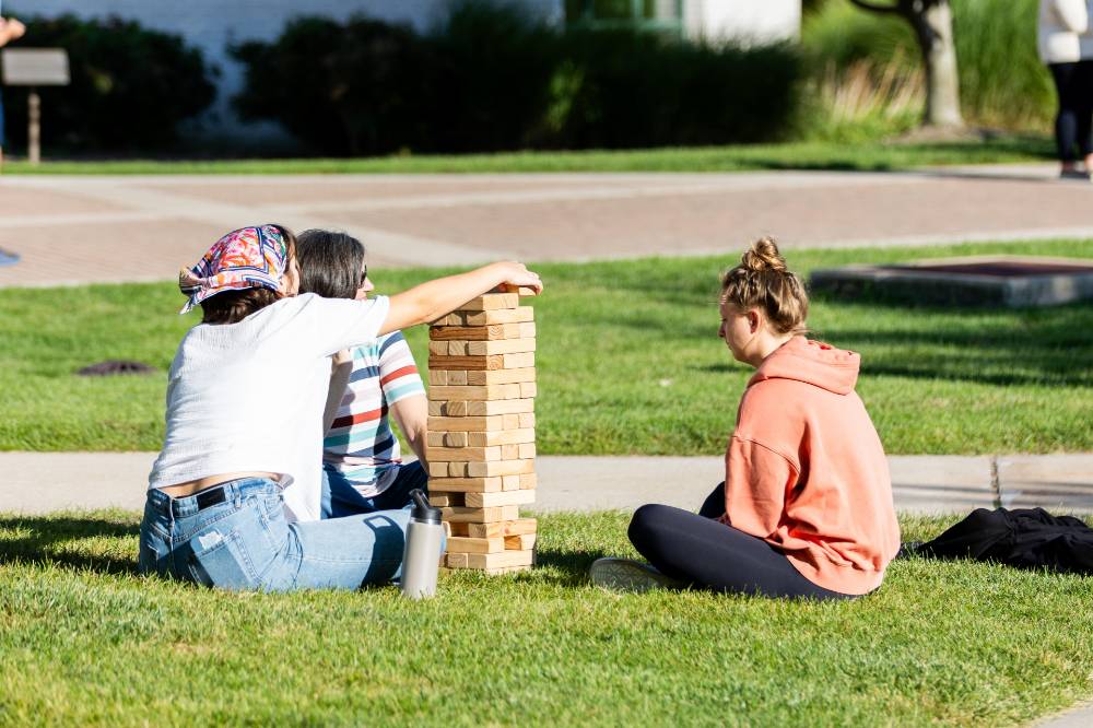 Students playing Jenga and stacking blocks on Kirkhof Lawn.